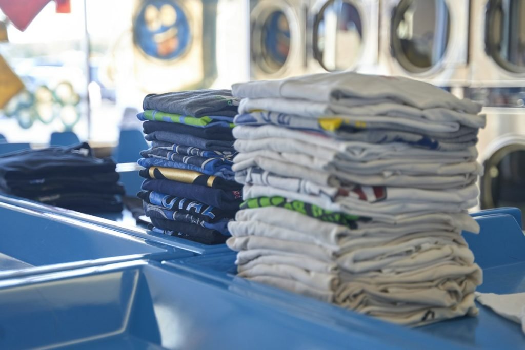 Neat stacks of folded clothes on a blue laundry counter