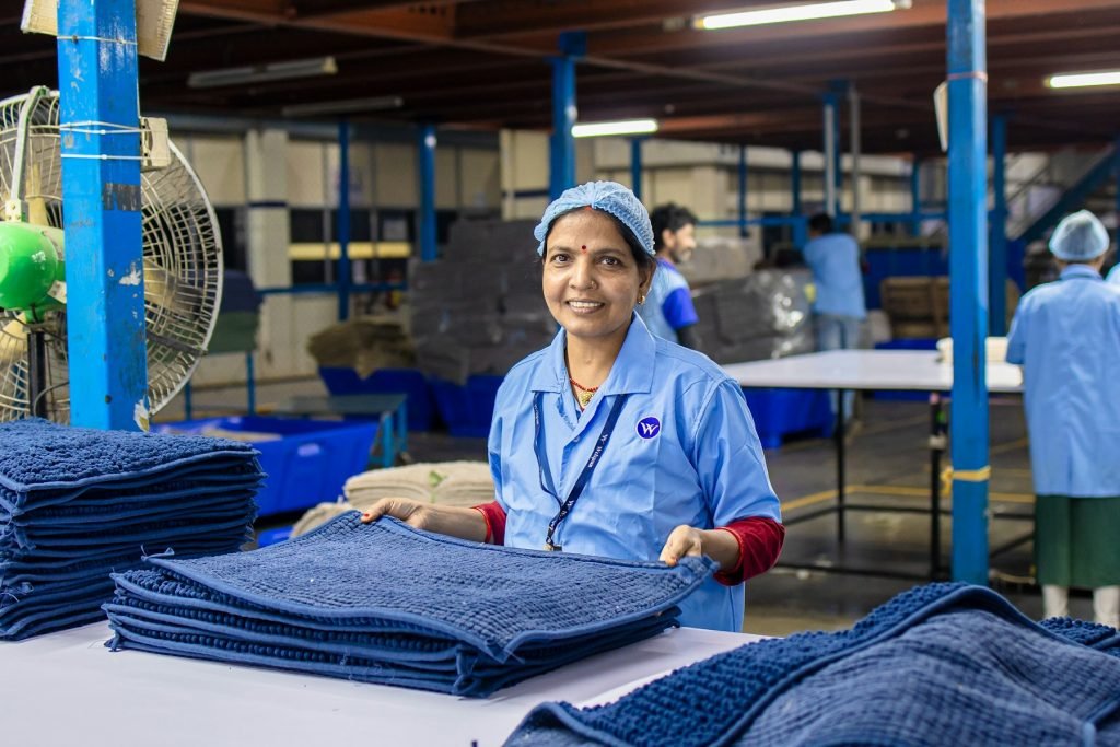 Laundry attendant in a blue uniform folding fresh towels
