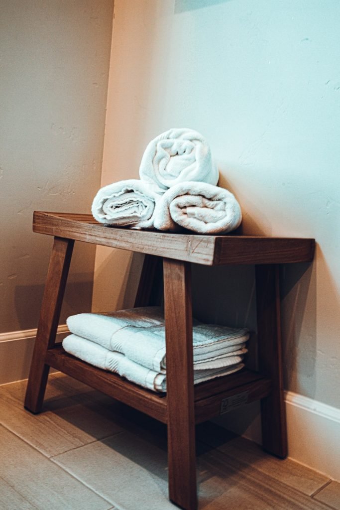 Rolled white towels on a wooden bench